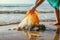 Beach cleanup: Human hands collect waste, protecting the sea