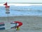 Beach closed sign and lifeguard surfboard by waves