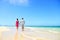 Beach couple holding hands walking on honeymoon