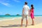 Beach couple looking at ocean view from behind