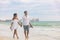 Beach couple romantic sunset walk Asian woman and Caucasian man relaxing walking on Florida vacation beach travel