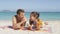 Beach couple sun tanning putting sunscreen suntan lotion on face laughing