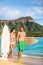 Beach couple surfing in Hawaii relaxing at sunset standing with surfboards on waikiki beach, Honolulu, Oahu, USA. Summer