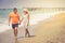 Beach couple walking on romantic travel honeymoon vacation summer holidays romance. Young happy lovers, Caucasian woman and man ho