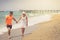 Beach couple walking on romantic travel honeymoon vacation summer holidays romance. Young happy lovers, Caucasian woman and man ho