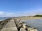 Beach with crystal clear water of the Mediterranean Sea next to a stone walkway and the city of BenicÃ¡sim-BenicÃ ssim, in Castell