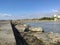 Beach with crystal clear water of the Mediterranean Sea next to a stone walkway and the city of BenicÃ¡sim-BenicÃ ssim, in Castell