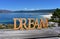 Beach with Dream wooden sign. Galicia, Spain, sunny day.