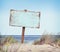 Beach with Empty Plank Sign