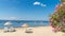 Beach of Erdek with beach umbrellas and pink flowers with a view of Marmara sea