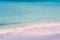 The beach with fine pink sand, bathed by the clear waves of the
