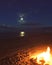 Beach fire under moonlight