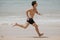 Beach fitness man runner running training cardio. Healthy lifestyle male athlete doing exercise living an active life working out