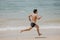 Beach fitness man runner running training cardio. Healthy lifestyle male athlete doing exercise living an active life working out