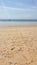 a beach with footprints in the sand and a boat in the distance, bali nusa penida