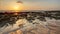 Beach in golden sunset light during low tide showing sand format