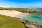 Beach with grass, rocks and sand