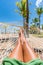 Beach hammock vacation woman feet selfie. Girl relaxing taking pov picture of her legs and feet sun tanning in tropical summer