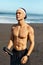 Beach. Handsome Man On Workout Break Portrait. Shirtless Guy Holding Bottle Of Protein Shake And Looking Away.