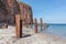 Beach Helgoland island with red cliffs and rusty iron pillars