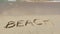 BEACH inscription on the sand with sea waves comes with slow motion. Concept of vacation and holiday