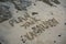 Beach inscription in the sand your vacation plan next to the stones