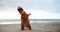 Beach, karate and adult in dinosaur costume on sand by ocean or sea for fitness and training. Exercise, health and