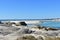 Beach with lake and turquoise clear water. Bright sand, rocks, dunes and vegetation. Blue sea with small waves and foam. Galicia,