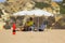 A beach life guard under the shade of his sun brolly while scanning the beach in Albuferia in Portugal