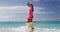 Beach life. Woman on caribbean luxury travel beach vacation walking on tropical summer holidays wearing sun hat, red