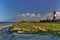 Beach with lighthouse, fence, sky, clouds