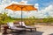 Beach Lounge Chairs with towels under umbrella at the poolside o