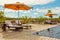 Beach Lounge Chairs with towels under umbrella at the poolside o