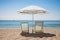 beach loungers under a parasol by the sea