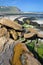 The beach at low tide with colorful rocks in the foreground at Cap Gris Nez, Cote d`Opale, Pas de Calais, Hauts de France, France