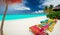 Beach in the Maldives with white coral sand in the blue lagoon, colorful sun loungers, beautiful view. AI generated illustration