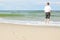 Beach man standing water back view shallow dof footprints