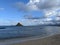 Beach with MokoliÊ»i isalnd or Chinaman's Hat in the distance