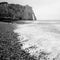 Beach near the French city of Etretat with cliffs Falaise d'Aval