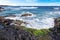 Beach near the Hanga Roa village on Easter Island, against a blue sky covered by white clouds.