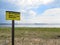 Beach, no lifeguard, swim at your own risk signage.