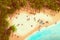 Beach and ocean surrounded by palm trees, striped beach, umbrellas and sunbeds, top view. Summer illustration. Generative AI