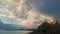 Beach overgrown with bushes, buildings at dawn with clouds