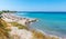 Beach with people, umbrellas and sunbeds near ancient city of Kamiros Rhodes, Greece