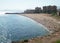 Beach with pier and fishermen from afar