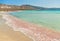 Beach with pink sand and gentle surf of turquoise blue sea