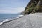 Beach Ponta de Sol pebble beach and rocky green coastline with cliffs, Madeira island, Portugal