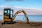 The beach is prepared for the season with a small excavator