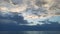 Beach, quiet water against the background of dawn with clouds