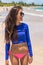 Beach rashguard bikini woman wearing swim shirt rash guard for sun protection against solar uv rays. Asian girl in